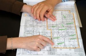 Photo of two people looking at a floorplan - Building a house