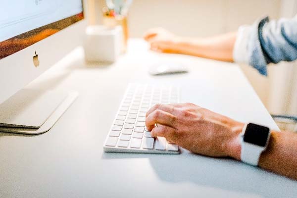 Photo of a man working at an Apple computer